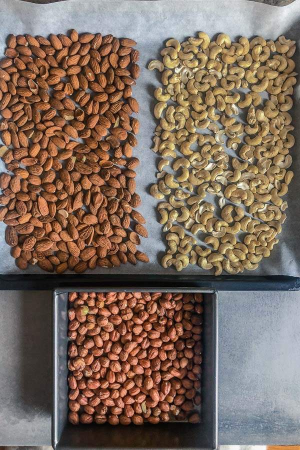 Raw nuts in trays: almonds, hazelnuts, cashew nuts